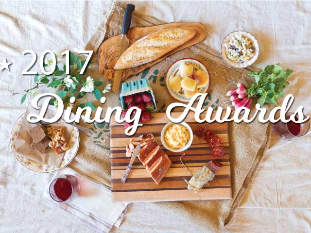 Overhead spread of bread, charcuterie, strawberries and wine on linen, with overlay text "2017 Dining Awards.